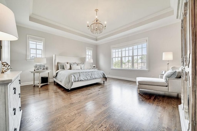 bedroom with ornamental molding, an inviting chandelier, dark hardwood / wood-style flooring, and a tray ceiling