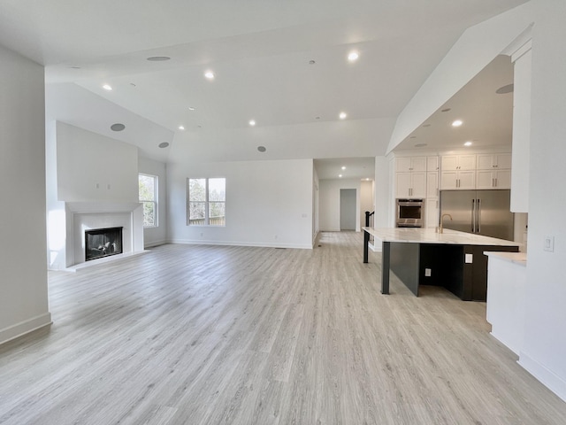 living room featuring lofted ceiling and light wood-type flooring