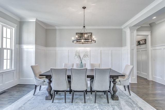 dining room with hardwood / wood-style flooring, ornamental molding, a healthy amount of sunlight, and an inviting chandelier