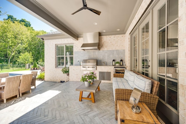 view of patio with ceiling fan, area for grilling, and exterior kitchen