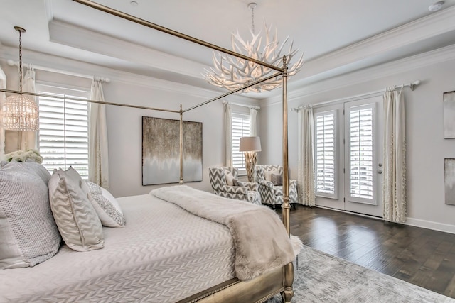 bedroom with dark hardwood / wood-style flooring, a tray ceiling, access to exterior, and a chandelier