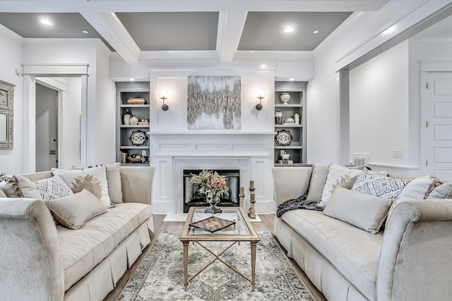 living room with built in shelves, a fireplace, light hardwood / wood-style floors, and beamed ceiling