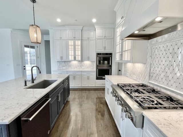 kitchen featuring sink, appliances with stainless steel finishes, white cabinets, decorative light fixtures, and custom exhaust hood