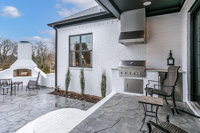 view of patio with an outdoor kitchen, an outdoor fireplace, and a grill