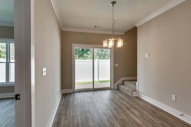 empty room with crown molding, a chandelier, and hardwood / wood-style flooring