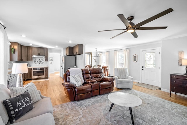 living room featuring crown molding, ceiling fan, and light hardwood / wood-style flooring