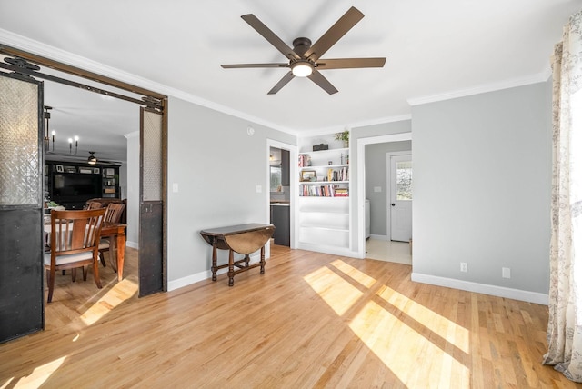 living room with hardwood / wood-style flooring, ornamental molding, built in features, and ceiling fan