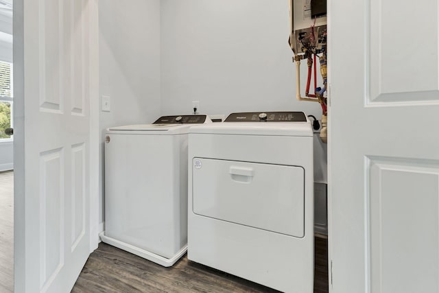 clothes washing area with washing machine and dryer and dark hardwood / wood-style flooring