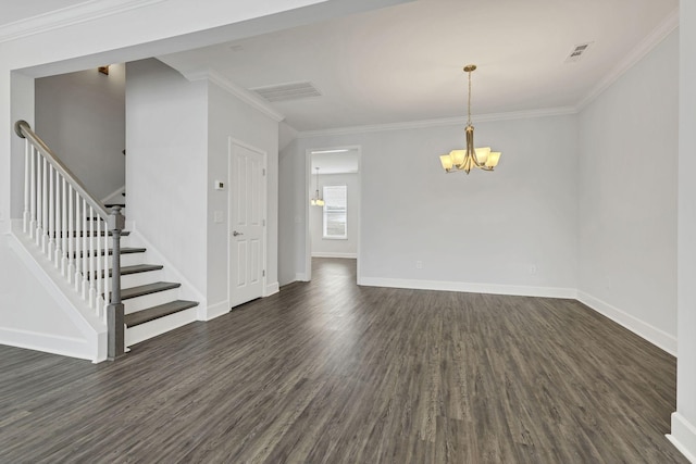 spare room with dark wood-type flooring, ornamental molding, and a chandelier