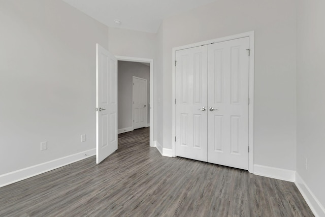 unfurnished bedroom featuring dark hardwood / wood-style flooring and a closet