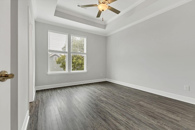 empty room with ceiling fan, ornamental molding, dark hardwood / wood-style flooring, and a raised ceiling