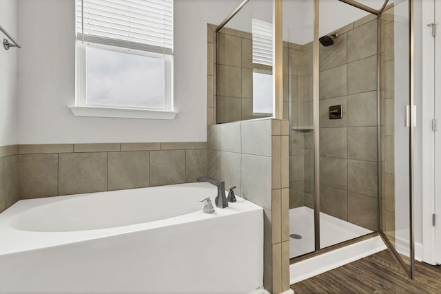 bathroom with hardwood / wood-style floors and separate shower and tub