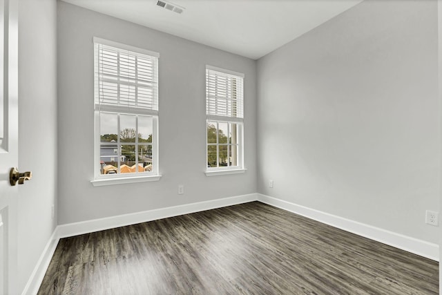 unfurnished room featuring a healthy amount of sunlight and dark hardwood / wood-style floors