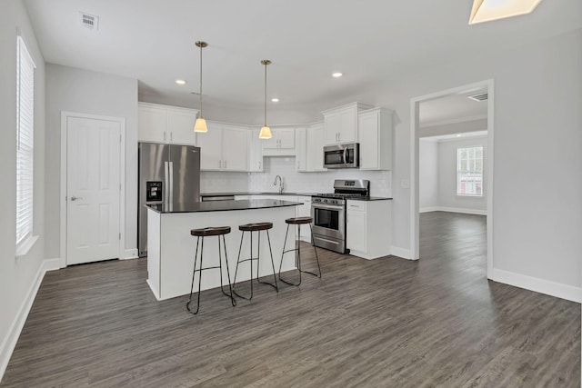 kitchen featuring dark hardwood / wood-style flooring, hanging light fixtures, stainless steel appliances, and white cabinets