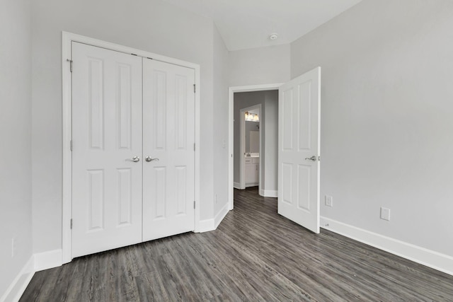 unfurnished bedroom with dark wood-type flooring and a closet