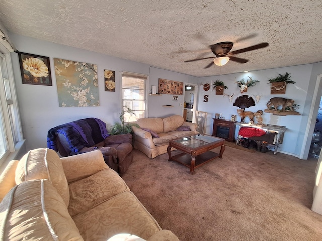 carpeted living room with ceiling fan and a textured ceiling