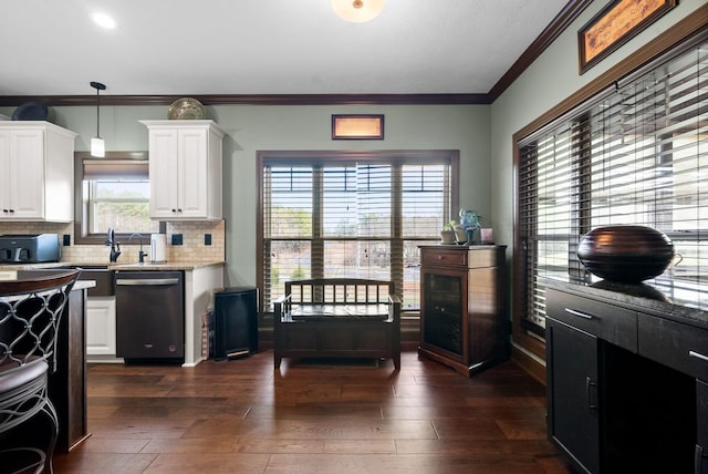 kitchen with hanging light fixtures, light stone counters, white cabinets, dark hardwood / wood-style flooring, and stainless steel dishwasher