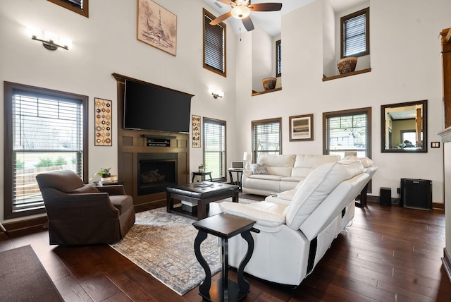 living room with dark wood-type flooring and ceiling fan