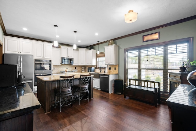 kitchen featuring a center island, appliances with stainless steel finishes, dark hardwood / wood-style floors, pendant lighting, and light stone countertops