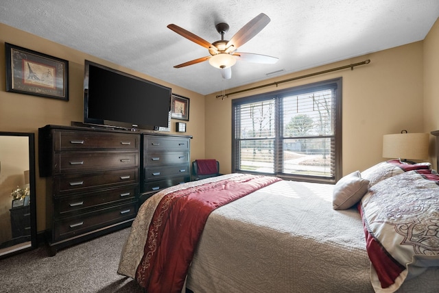 carpeted bedroom with ceiling fan and a textured ceiling