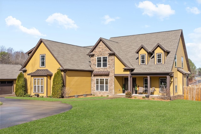 view of front facade featuring a garage, covered porch, and a front lawn