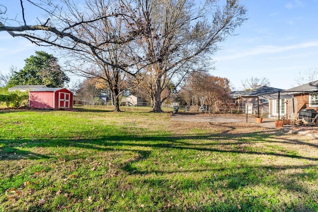 view of yard featuring a storage unit, an outdoor structure, and fence