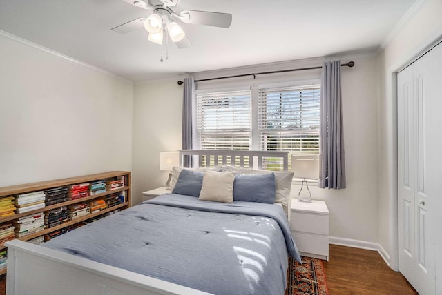 bedroom featuring dark hardwood / wood-style flooring, crown molding, ceiling fan, and a closet