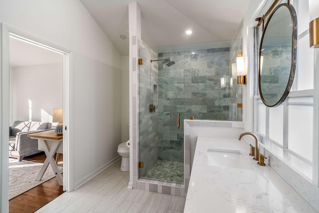 full bath with vanity, baseboards, a shower stall, vaulted ceiling, and toilet