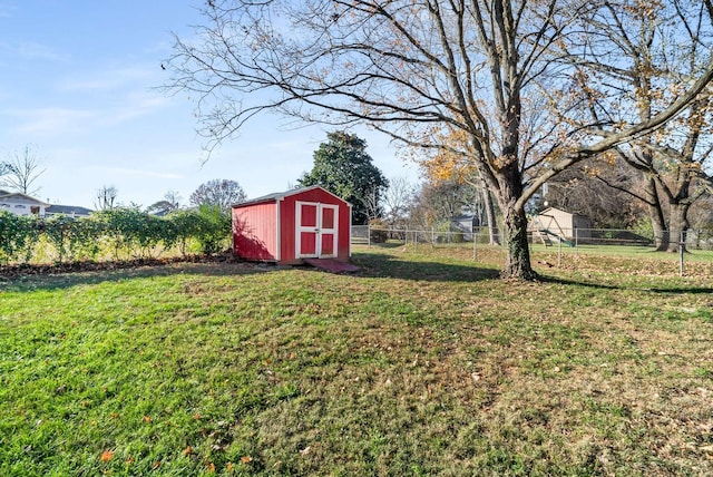 view of yard with an outbuilding, a storage shed, and fence