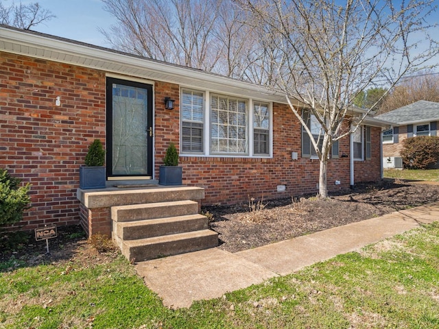 doorway to property with brick siding