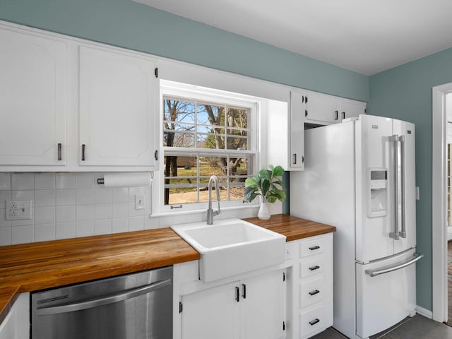 kitchen featuring a sink, wood counters, white refrigerator with ice dispenser, decorative backsplash, and dishwasher