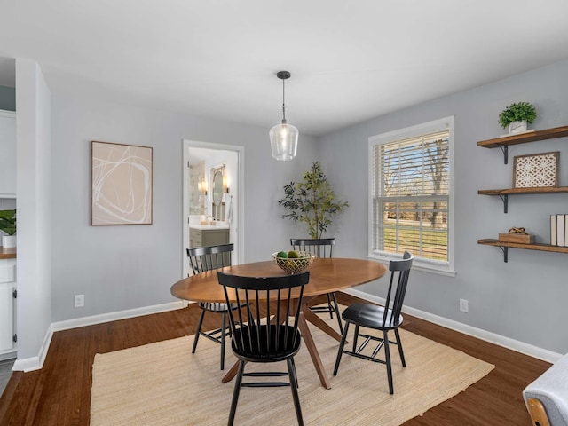 dining space featuring baseboards and wood finished floors