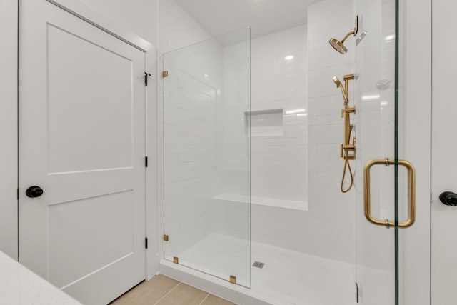 bathroom with an enclosed shower and tile patterned floors