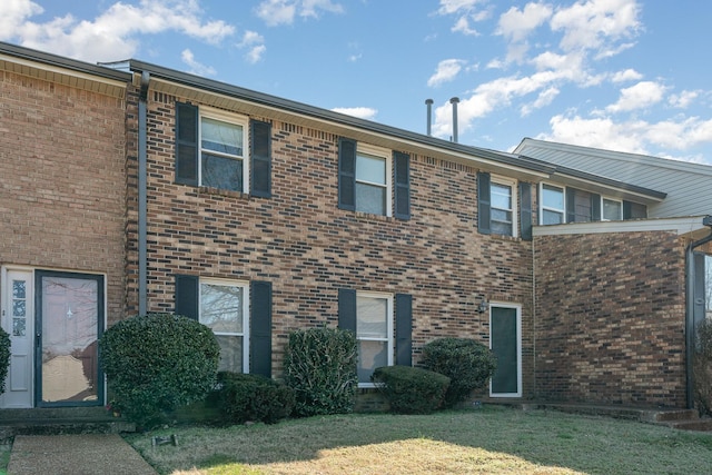 townhome / multi-family property featuring a front lawn