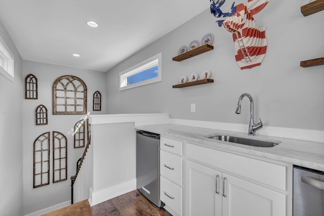 bar with light stone counters, white cabinetry, plenty of natural light, and sink