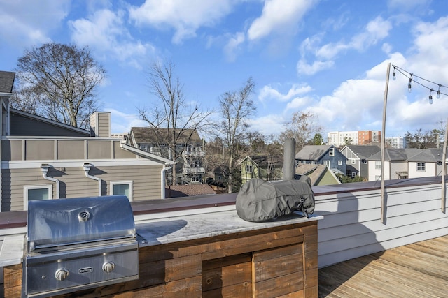 wooden terrace with an outdoor kitchen and a grill