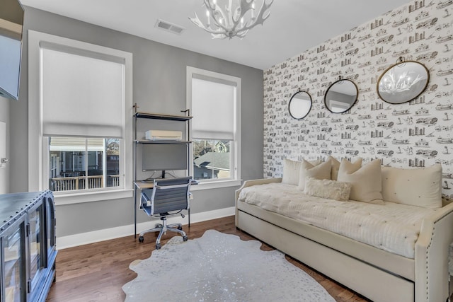 bedroom with an inviting chandelier and hardwood / wood-style flooring