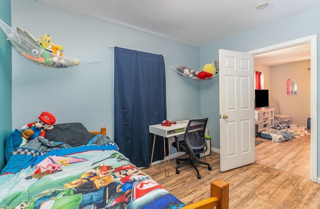 bedroom with wood-type flooring and a textured ceiling