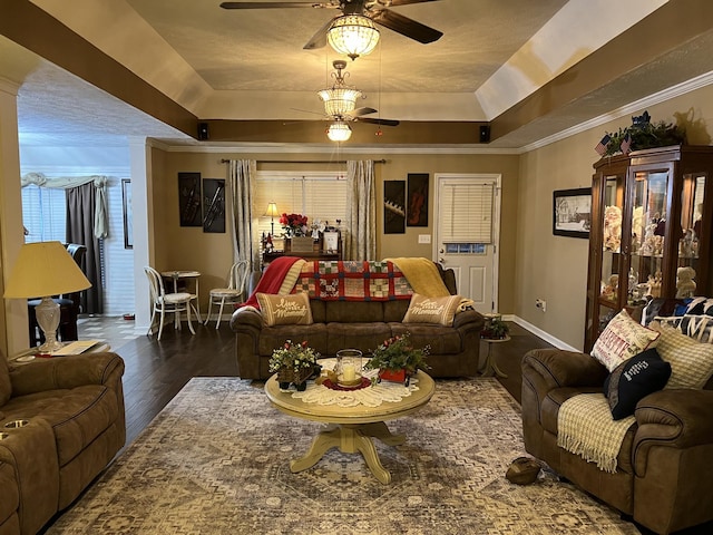 living room with crown molding, ceiling fan, dark hardwood / wood-style flooring, and a tray ceiling