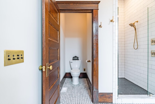 bathroom with tiled shower, tile patterned floors, and toilet