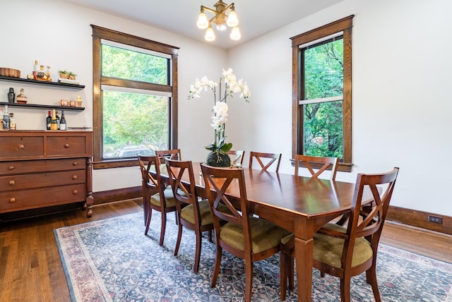 dining room featuring a notable chandelier and dark wood-type flooring