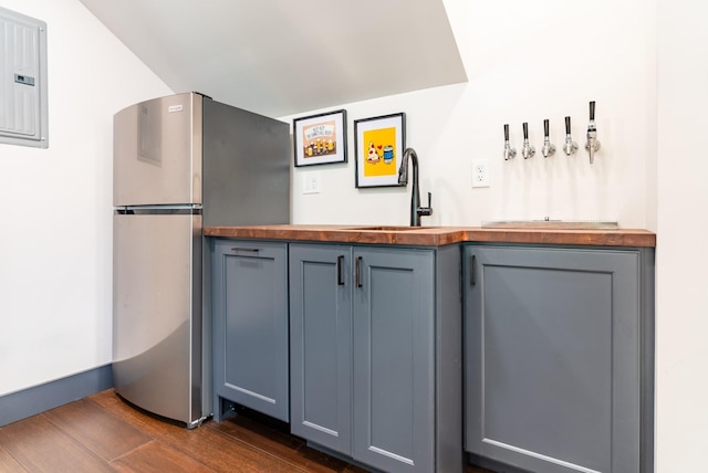 kitchen featuring sink, stainless steel fridge, dark hardwood / wood-style flooring, and electric panel