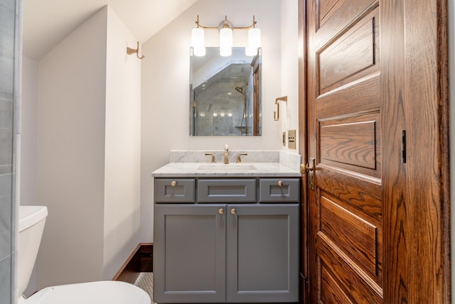 bathroom featuring vanity, vaulted ceiling, and toilet