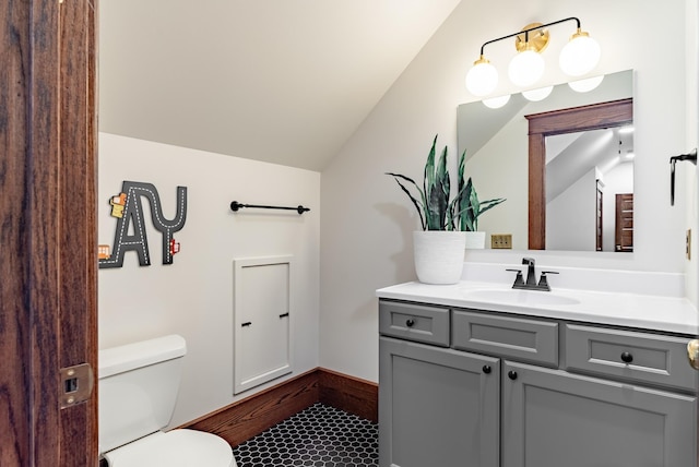 bathroom with vanity, toilet, and vaulted ceiling