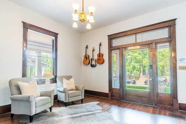 doorway to outside featuring dark hardwood / wood-style flooring and a chandelier