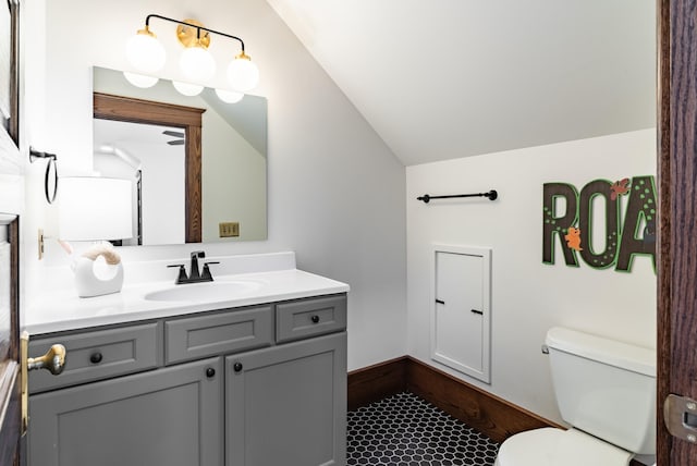 bathroom featuring vanity, vaulted ceiling, and toilet