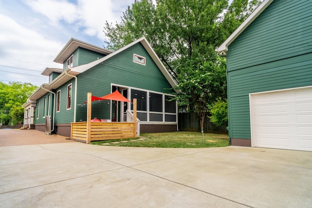 view of front of home featuring a garage and a sunroom