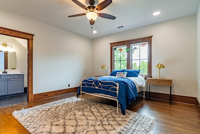 bedroom featuring sink, ensuite bath, dark hardwood / wood-style floors, and ceiling fan