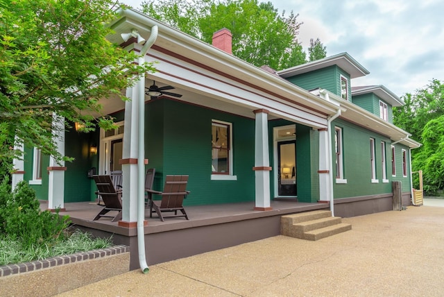 rear view of house featuring ceiling fan and a porch