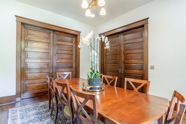 dining area with an inviting chandelier and dark hardwood / wood-style flooring